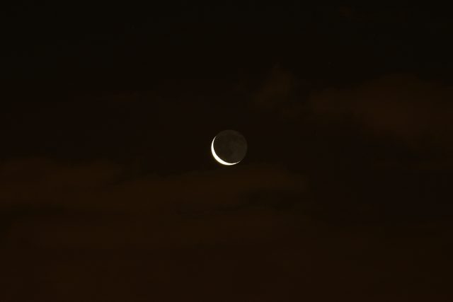 The Moon is finally leaving the clouds and shows its elegant Earthshine