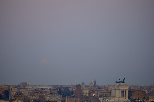 A pale, very elegant Supermoon rises above Rome: the thick haze makes it quite red. 19 Feb. 2019