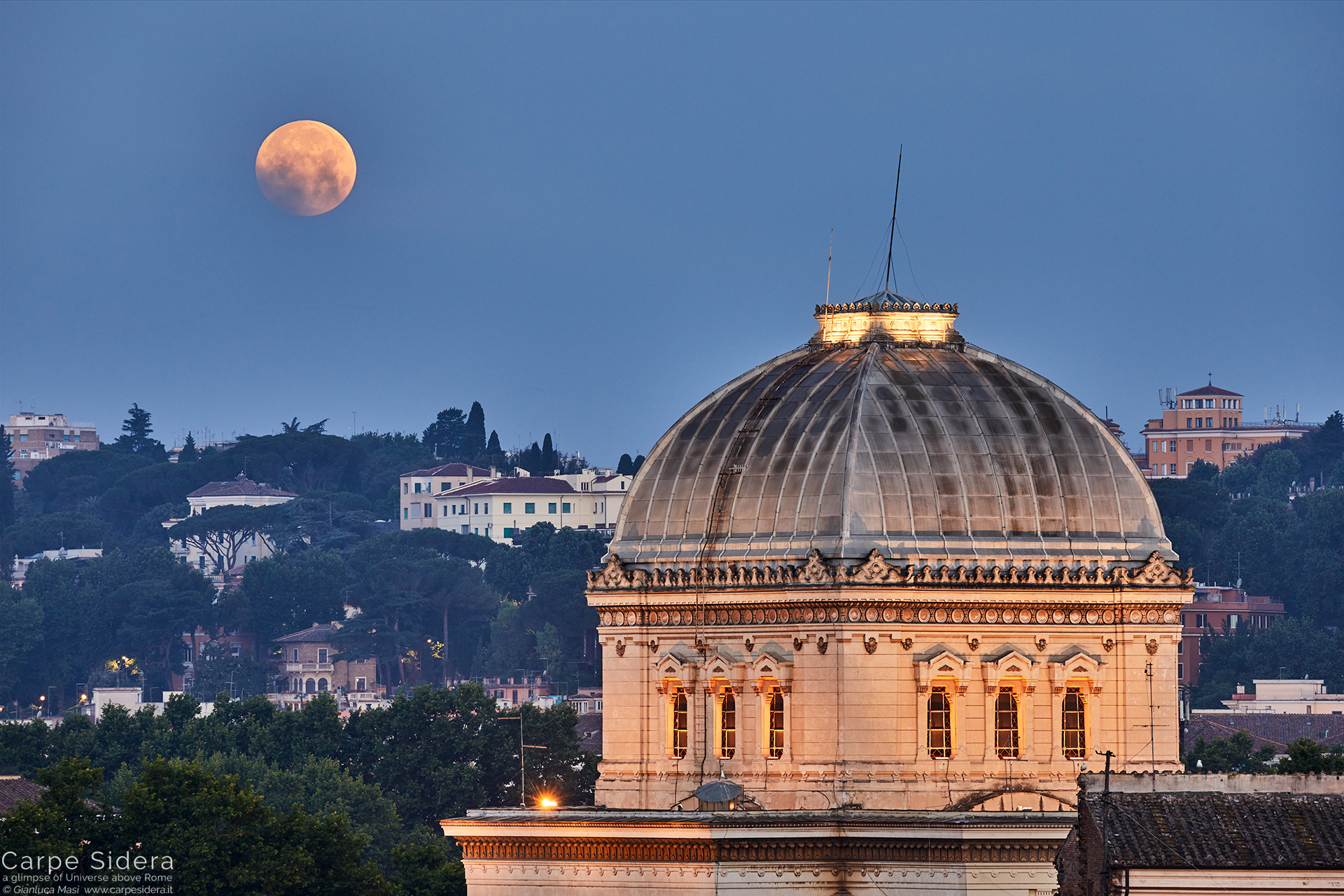 While it sets behind the Synagogue of Rome, the full Moon plays with some clouds